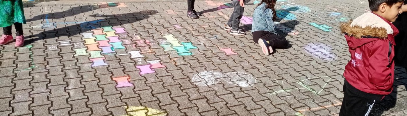 Kinder malen die Hermannstraße mit Straßenkreide